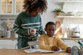 African American mother checking childs homework, helping son with learning at home Royalty Free Stock Photo