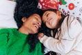 Mother and daughter lie and laugh on Christmas pillows