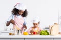 african american mother and daughter in chef hats cooking Royalty Free Stock Photo