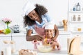 african american mother and daughter in chef hats mixing dough with whisk