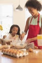 African American mother and daughter mixing cookie dough ingredients together in kitchen Royalty Free Stock Photo