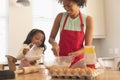African American mother and daughter mixing dry and wet ingredients together in kitchen Royalty Free Stock Photo
