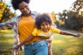 African American mother and daughter running trough park. Focus on little girl Royalty Free Stock Photo