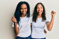 African american mother and daughter wearing casual white tshirt screaming proud, celebrating victory and success very excited Royalty Free Stock Photo