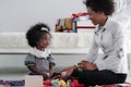 African american mother and girl child playing toy together