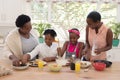 African american mother and grandmother teaching girl and boy cooking in the kitchen