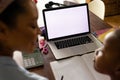 African american mother helping daughter with schoolwork using laptop at home, copy space on screen Royalty Free Stock Photo