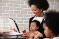 African american mother holding her baby boy on hands while working with laptop computer at home Royalty Free Stock Photo