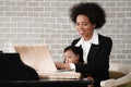 African american mother holding her baby boy on hands while working with laptop computer at home Royalty Free Stock Photo