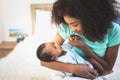 African American mother looking and holding hand, her 1-month-old baby newborn son lying in bed Royalty Free Stock Photo