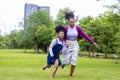 African American mother running barefoot on the grass lawn with her young daughter while having a summer picnic in the public park Royalty Free Stock Photo