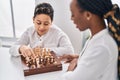 African american mother and son playing chess game sitting on table at home Royalty Free Stock Photo