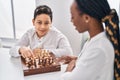 African american mother and son playing chess game sitting on table at home Royalty Free Stock Photo