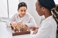 African american mother and son playing chess game sitting on table at home Royalty Free Stock Photo