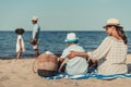 african american mother and son sitting on sand while father and daughter playing Royalty Free Stock Photo