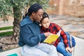 African american mother and son smiling confident reading book at park Royalty Free Stock Photo