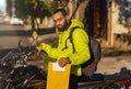 African American motorcycle courier on motorbike with envelope for delivery