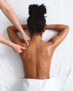 African american naked woman getting relaxing back massage on white Royalty Free Stock Photo