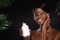 African american naked woman holding bottle