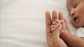 African american new born baby hand holding mom finger on white bed Royalty Free Stock Photo