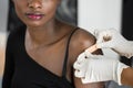 African American Nurse Applying Bandage And Covid-19 Vaccine