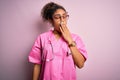 African american nurse girl wearing medical uniform and stethoscope over pink background bored yawning tired covering mouth with Royalty Free Stock Photo