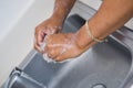 African-American nurse woman washing her hands in a stainless steel sink at a hospital or medical clinic Royalty Free Stock Photo