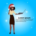 African american operator woman red hat hold laptop support service happy new year merry christmas concept flat blue Royalty Free Stock Photo