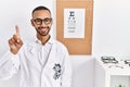 African american optician man standing by eyesight test showing and pointing up with finger number one while smiling confident and Royalty Free Stock Photo