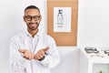 African american optician man standing by eyesight test smiling with hands palms together receiving or giving gesture Royalty Free Stock Photo