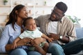 African American parents comforting crying kid on sofa Royalty Free Stock Photo