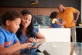 African American Parents Helping Children Studying Homework On Digital Tablets In Kitchen Royalty Free Stock Photo