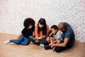 African American parents reading a fairy tale fable story for kids at home. Happy family sitting on the floor indoors. Royalty Free Stock Photo