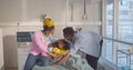 African-American parents in safety mask visit girl patient lying in medical bed in ward kids hospital Royalty Free Stock Photo
