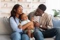 African American parents sitting with crying kid on sofa Royalty Free Stock Photo