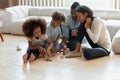 African American parents and two preschooler kids playing toy