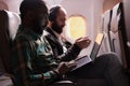 African american passenger working on laptop during sunset flight