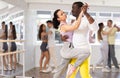 African American performing kizomba with woman in dance studio