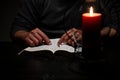 African American Person Studying the Bible in Dark Room Royalty Free Stock Photo