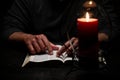 African American Person Studying the Bible Sitting at Desk with Candle Royalty Free Stock Photo