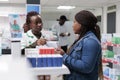 African american pharmacist consulting customer in drugstore