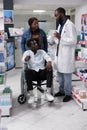 African american pharmacist helping man in wheelchair choosing medications Royalty Free Stock Photo
