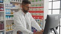 African american pharmacist working at the computer inside a modern drugstore Royalty Free Stock Photo