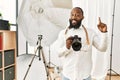 African american photographer man working at photography studio pointing finger up with successful idea Royalty Free Stock Photo
