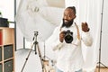 African american photographer man working at photography studio pointing fingers to camera with happy and funny face Royalty Free Stock Photo