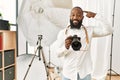 African american photographer man working at photography studio smiling pointing to head with one finger, great idea or thought, Royalty Free Stock Photo
