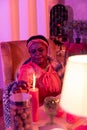 African american plump fortune-teller in ethnic adornments looking concentrated