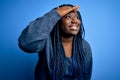 African american plus size woman with braids wearing casual sweater over blue background very happy and smiling looking far away Royalty Free Stock Photo