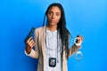 African american police woman holding gun and handcuffs relaxed with serious expression on face Royalty Free Stock Photo