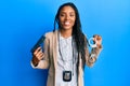 African american police woman holding gun and handcuffs smiling with a happy and cool smile on face Royalty Free Stock Photo